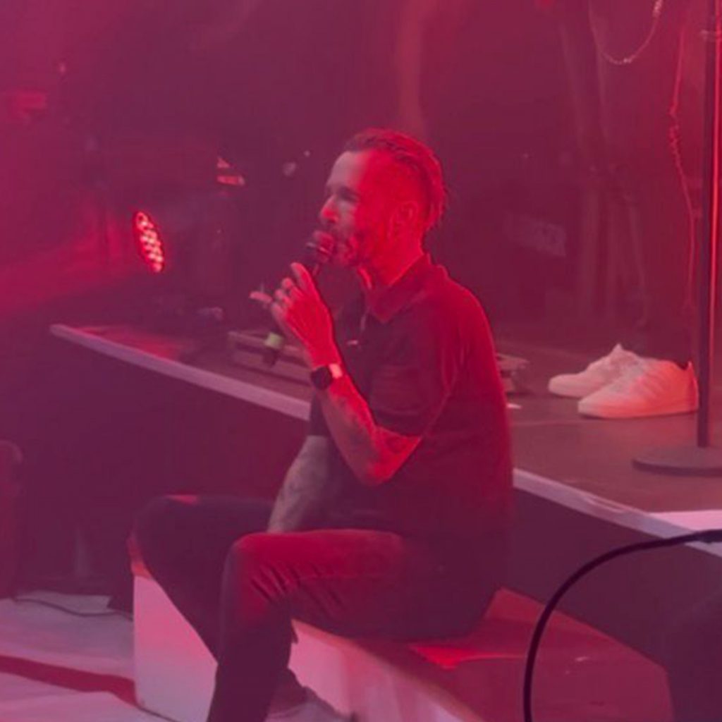 Sänger der Räuber, sitzend und singend auf der Bühne.